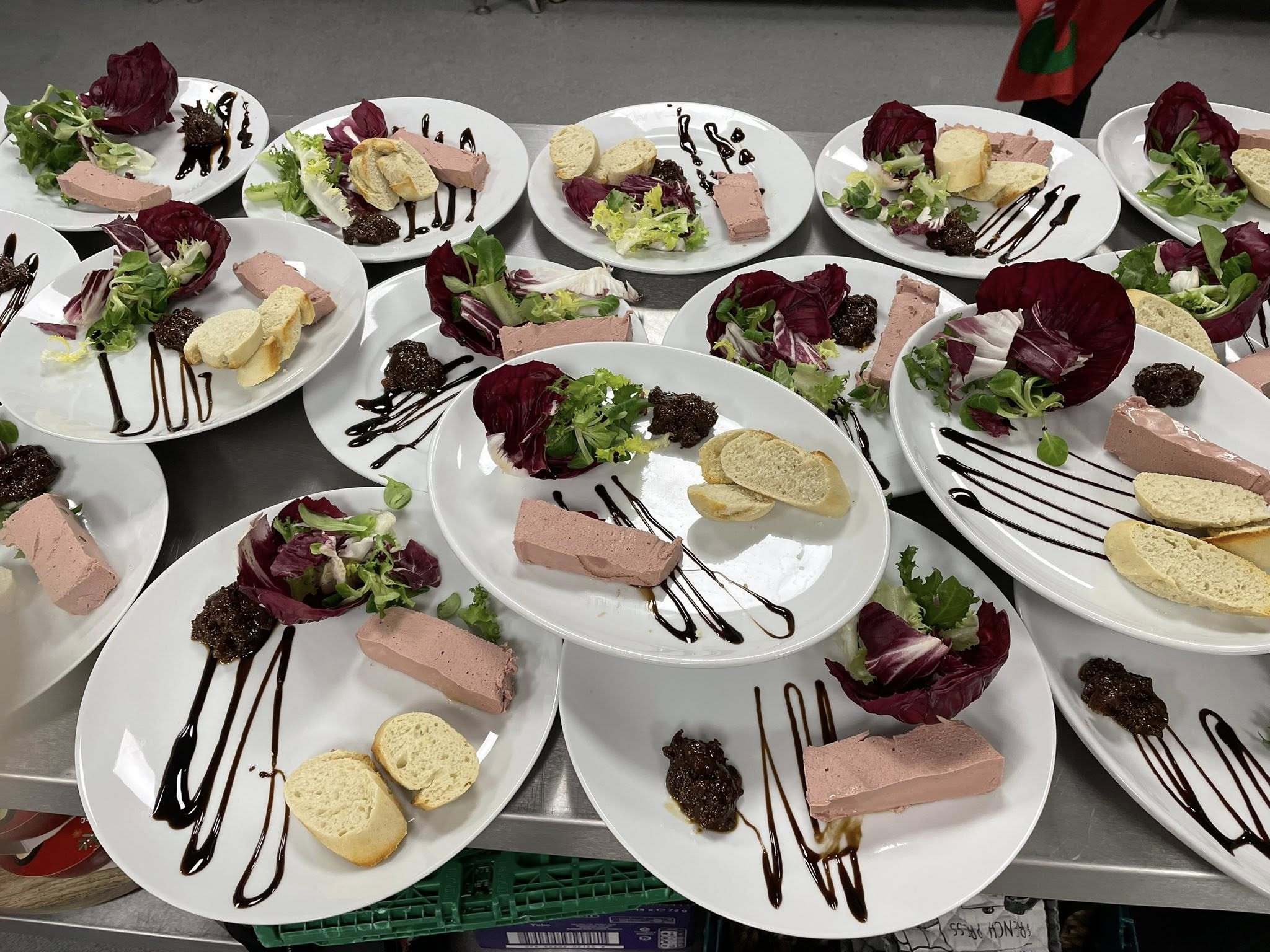 Multiple plates with paté, bread, and salad leaves